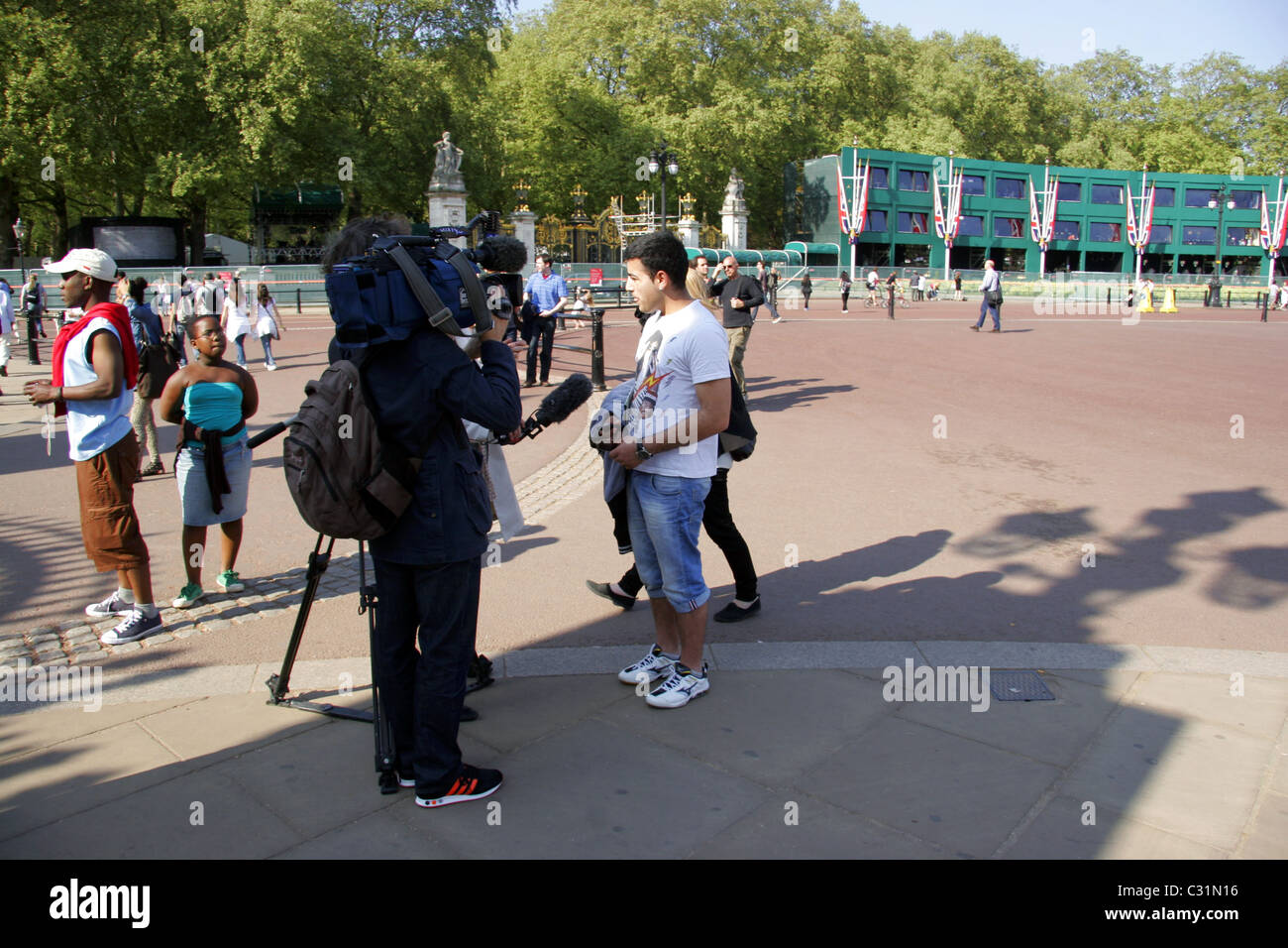 Member of the public being interviewed by television crew outside Buckingham Palace three days before the Royal Wedding. Stock Photo