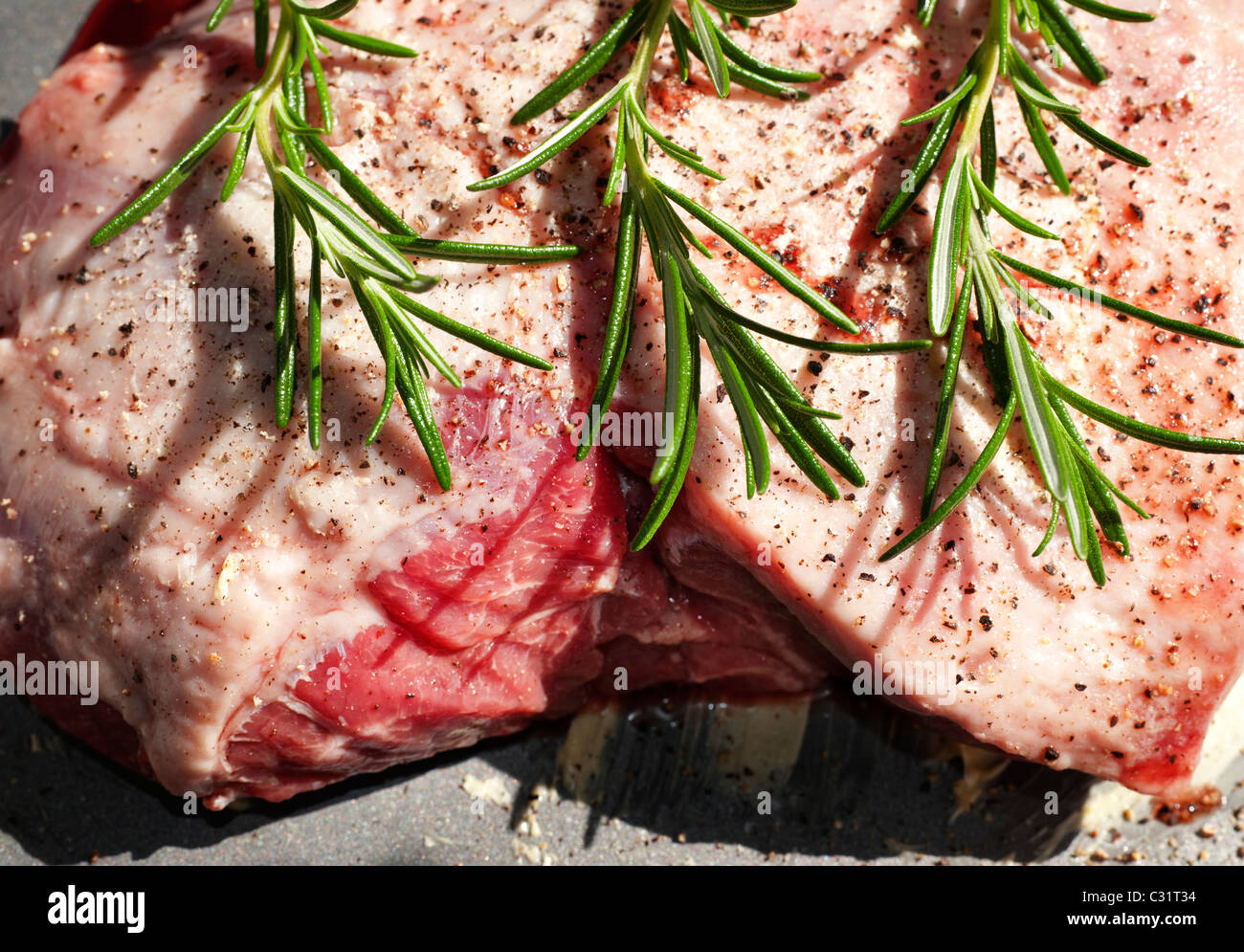 Fresh raw lamb shoulder joint prepared with rosemary and herbs ready for the oven Stock Photo