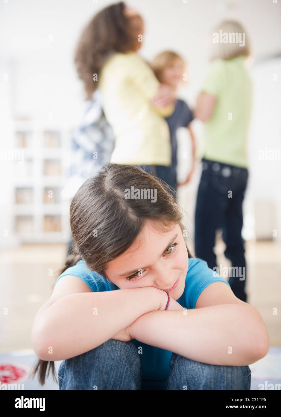 Lonely girl ignoring friends playing Stock Photo