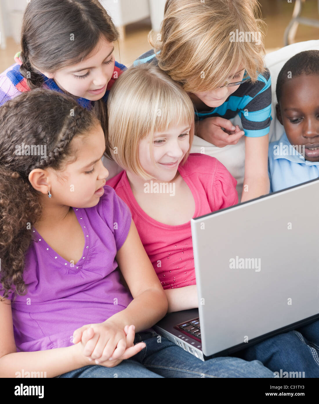 Friends using laptop together Stock Photo - Alamy