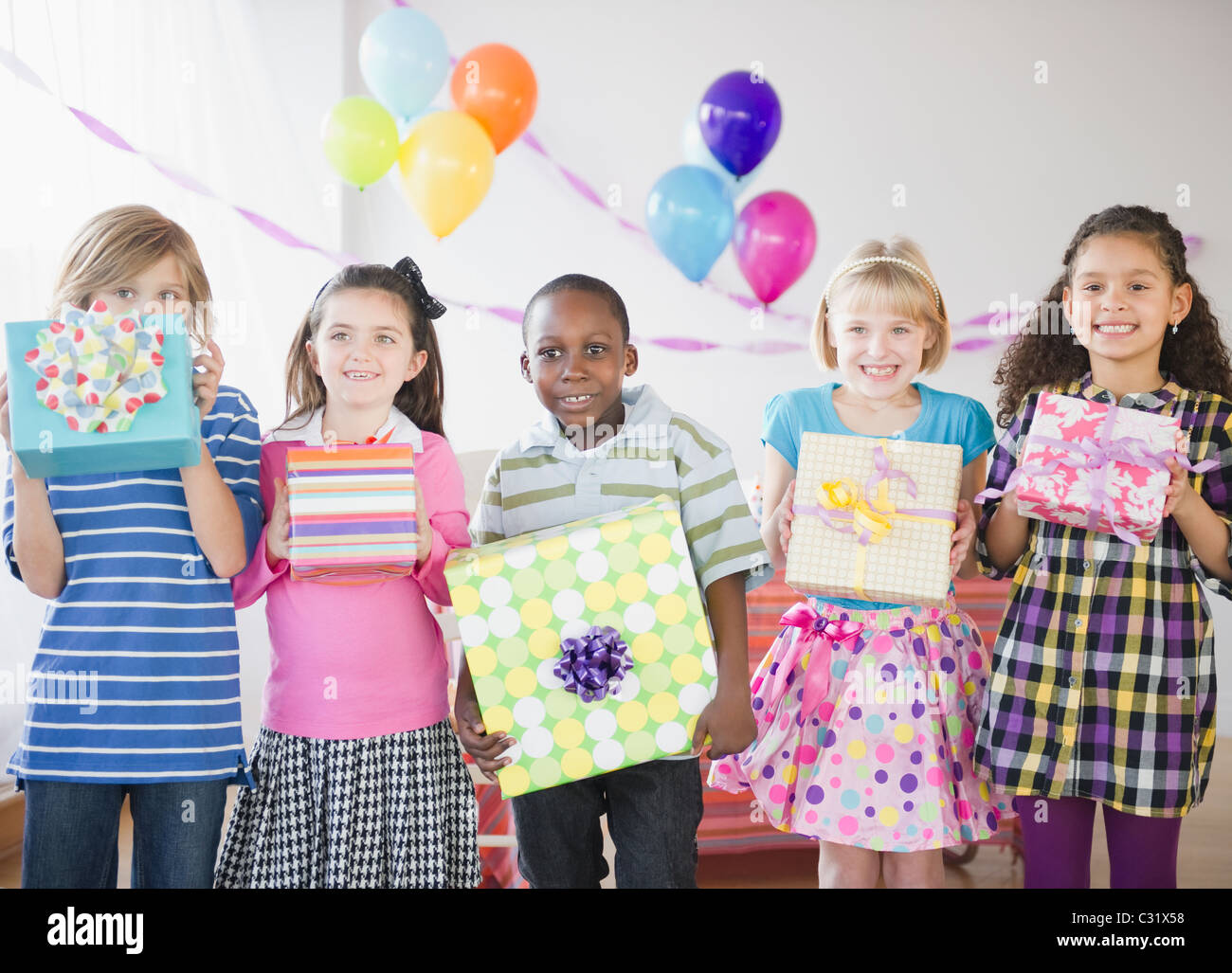 Children at birthday party holding gifts Stock Photo - Alamy