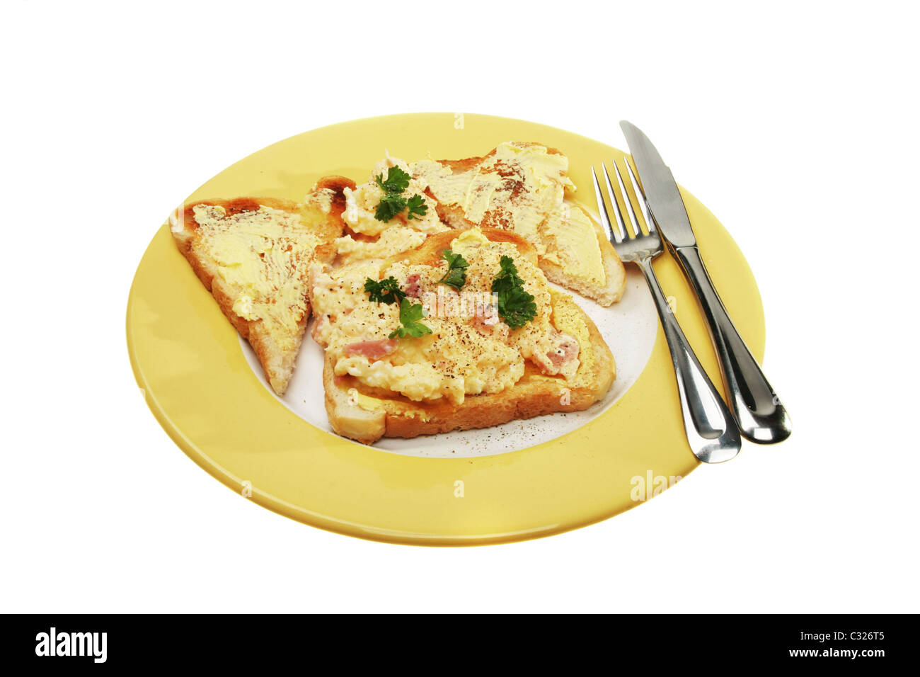 Scrambled eggs on toast on a plate with knife and fork Stock Photo