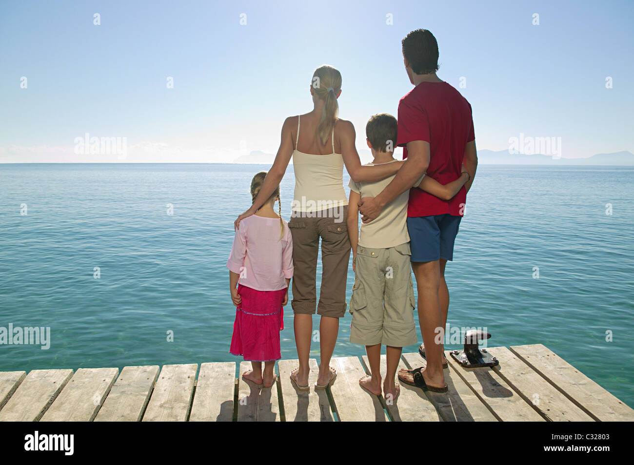Rear view of family standing on jetty Stock Photo