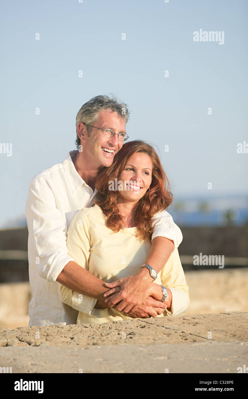 Mature couple outdoors, man with arms around woman Stock Photo