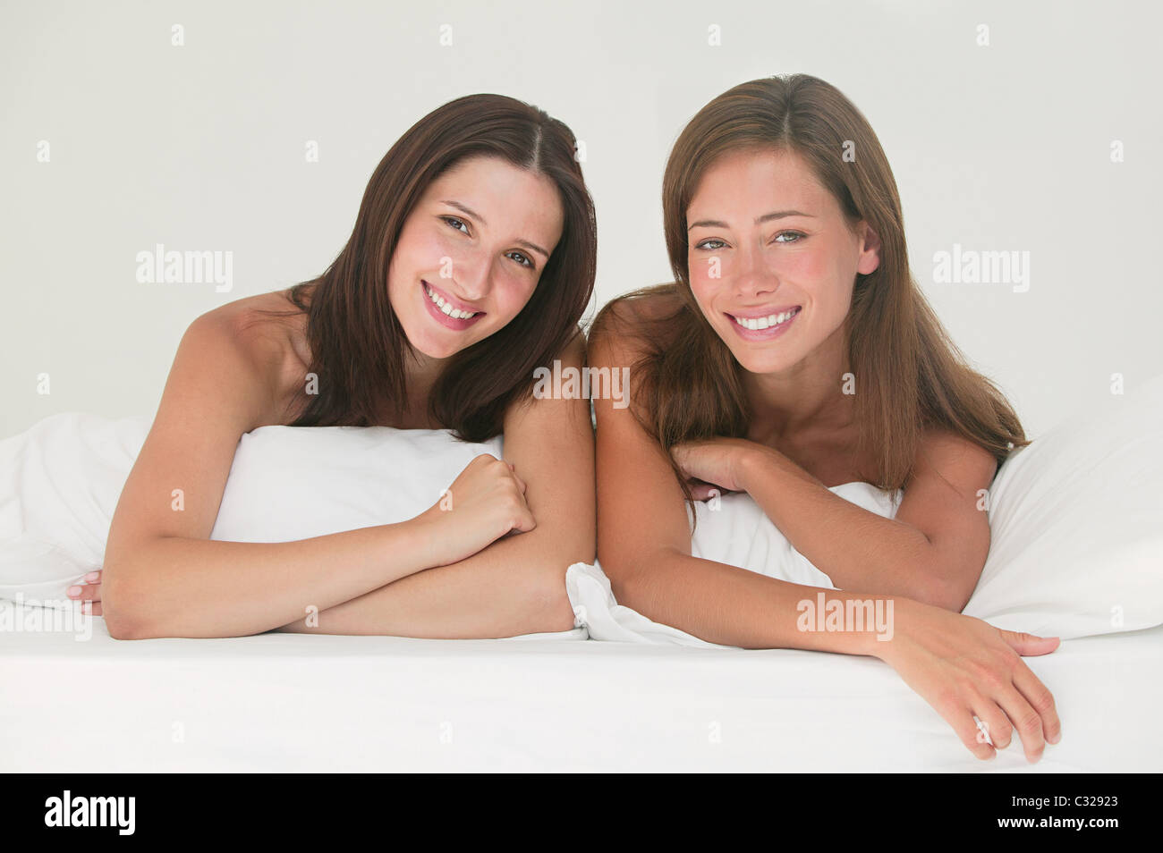 Two young women on a bed Stock Photo