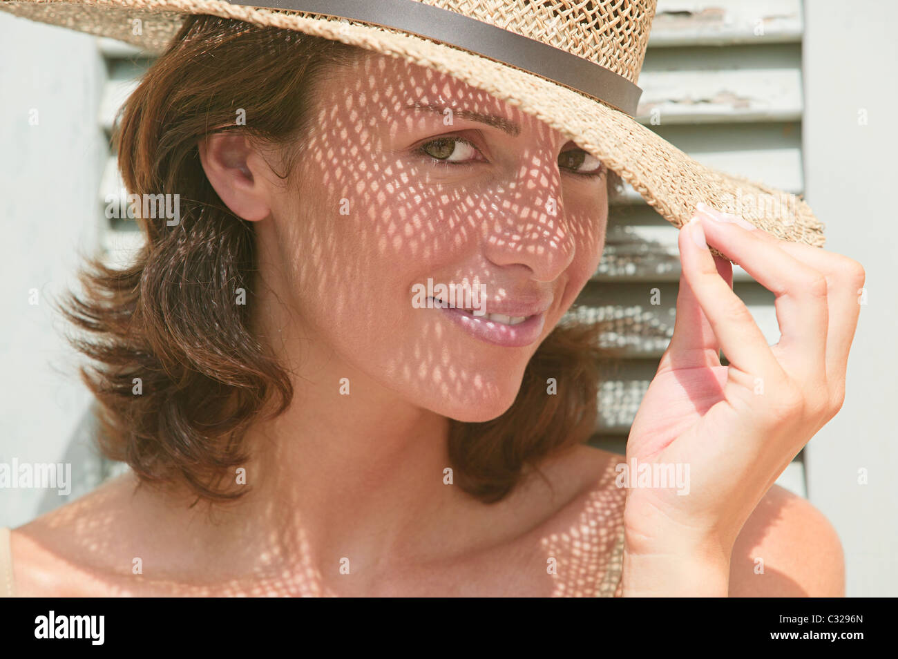 Woman wearing a sun hat with shadows on face Stock Photo