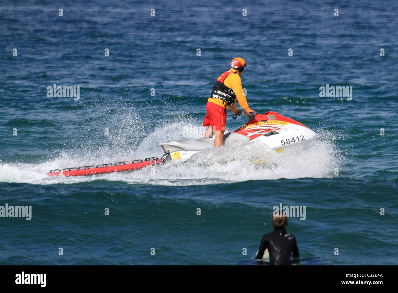 Australian surf lifesaver on a jetski patrols the beach in Australia Stock Photo