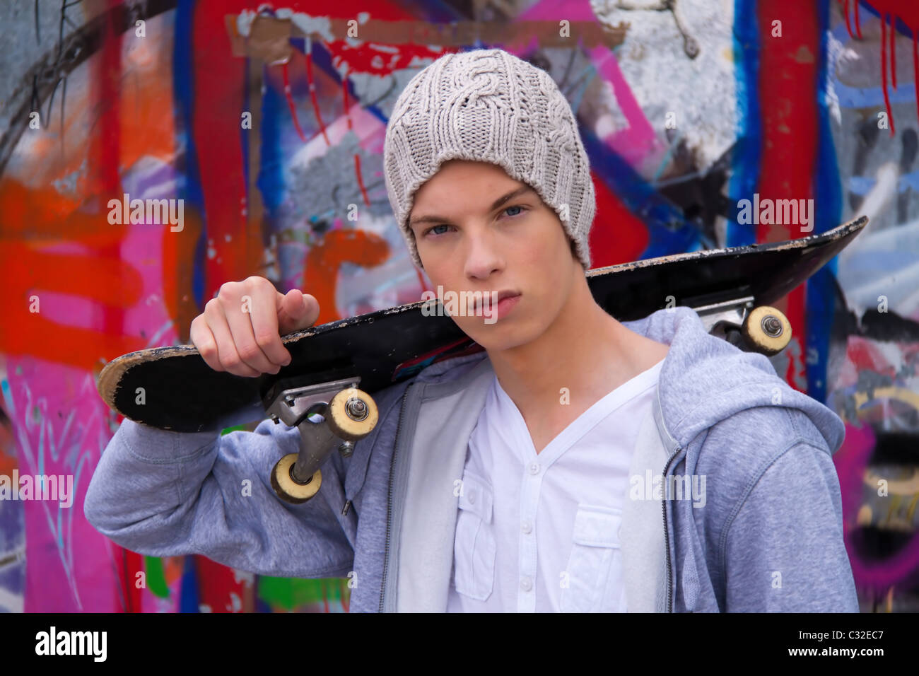 Cool-looking young man in front of graffiti Stock Photo