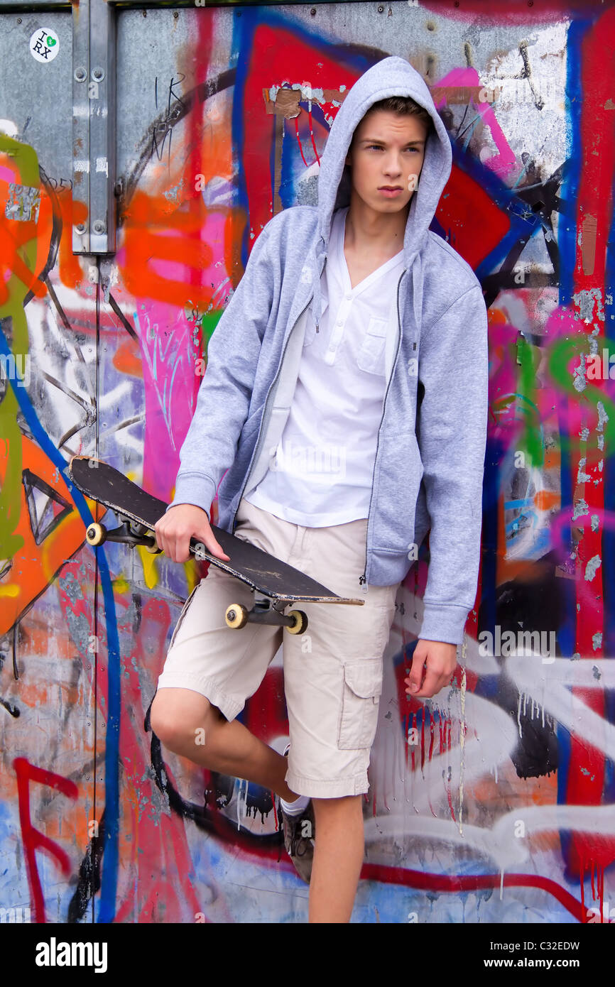 Cool-looking young man in front of graffiti Stock Photo
