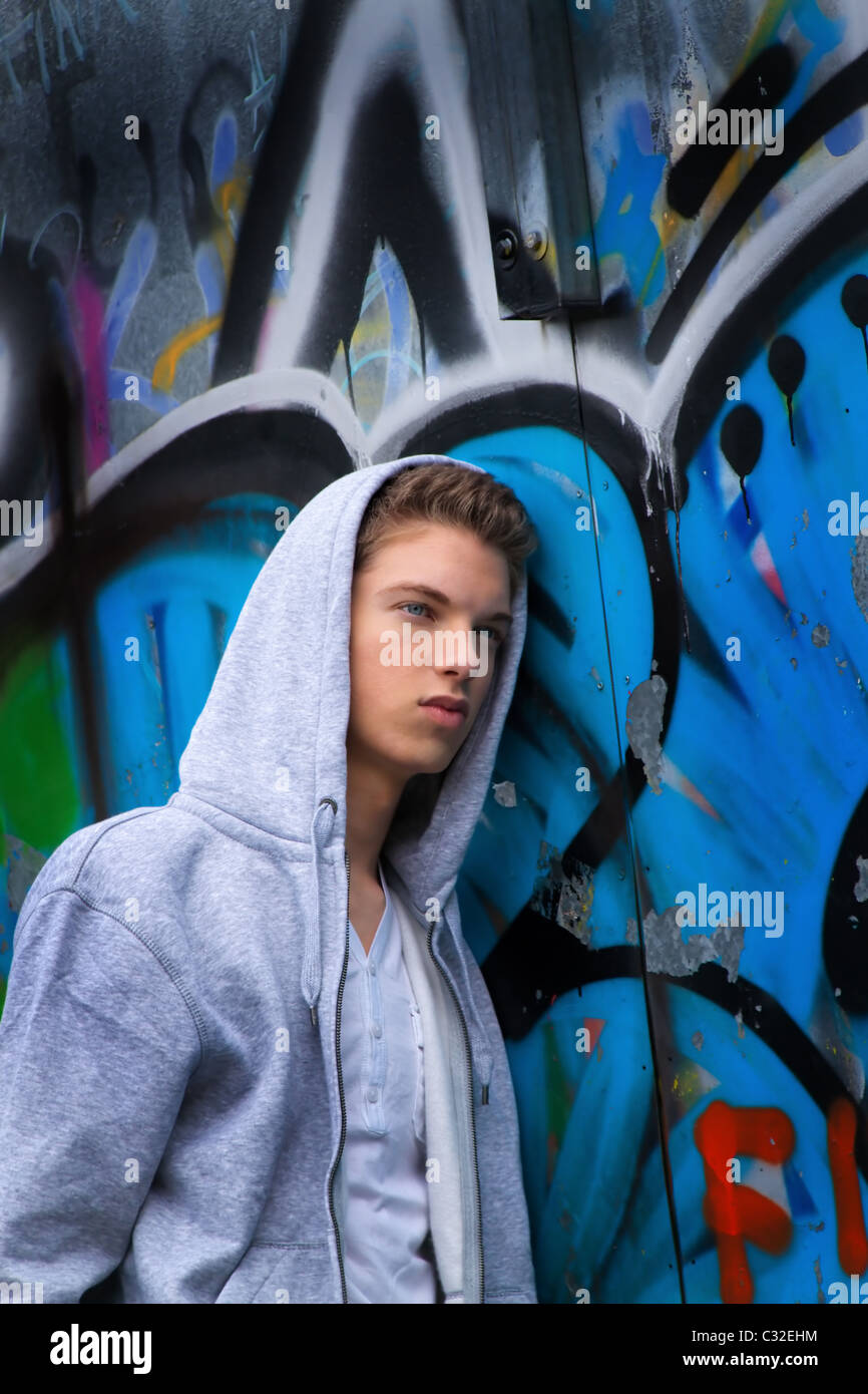 Cool-looking young man in front of graffiti Stock Photo