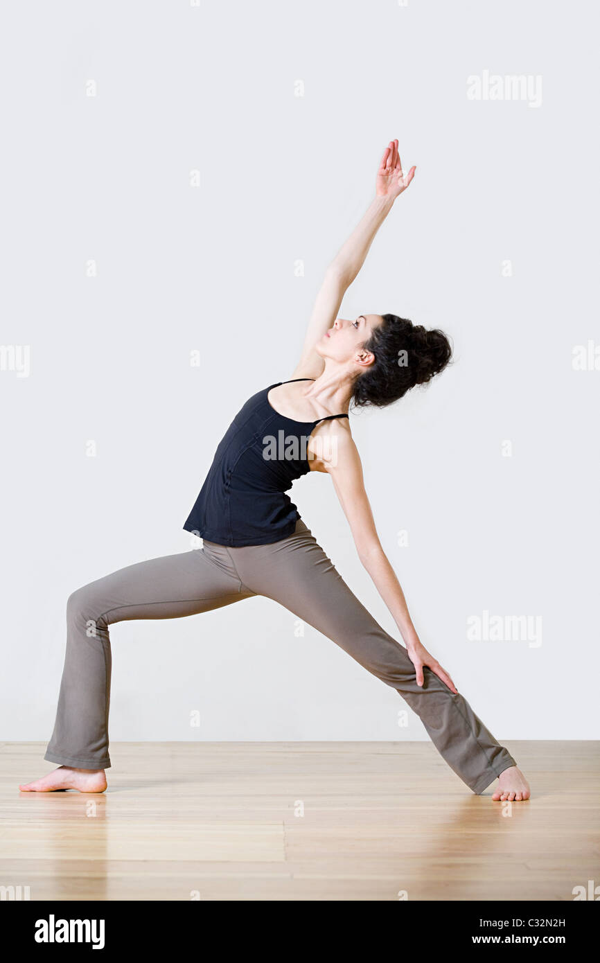 Woman in warrior position during yoga Stock Photo