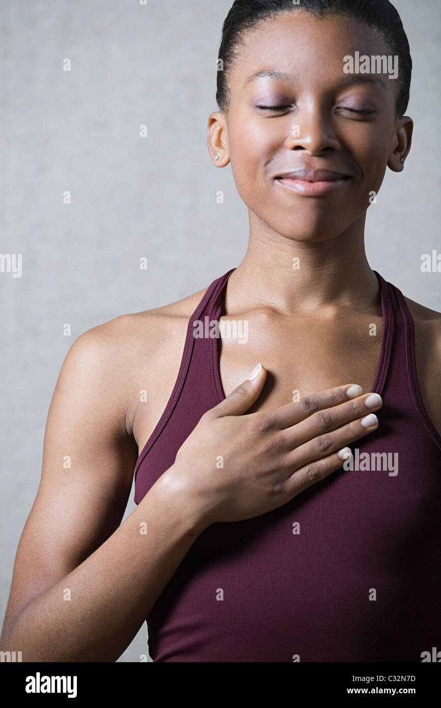Women breathing deeply, touching chest Stock Photo