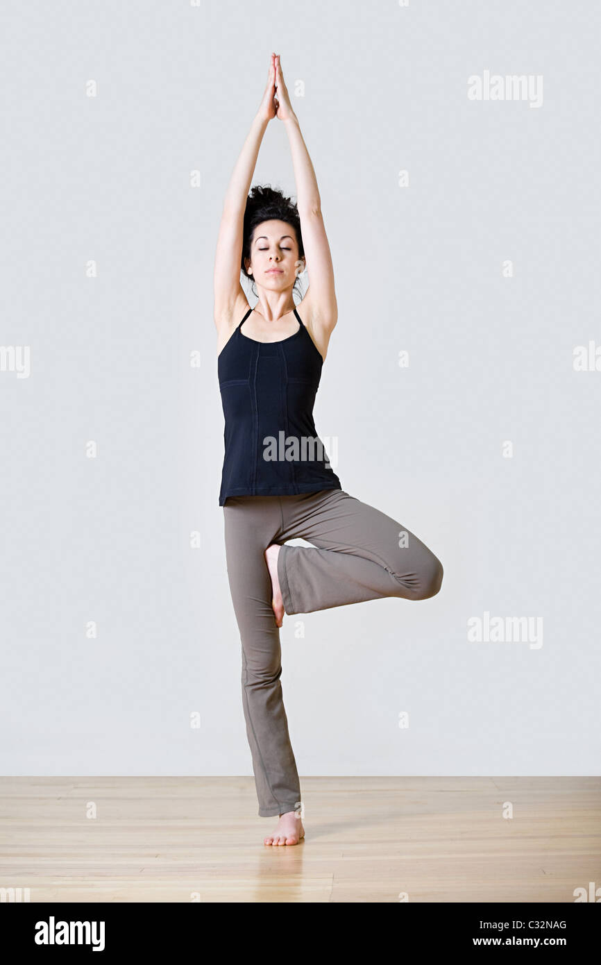 Woman in tree position during yoga Stock Photo
