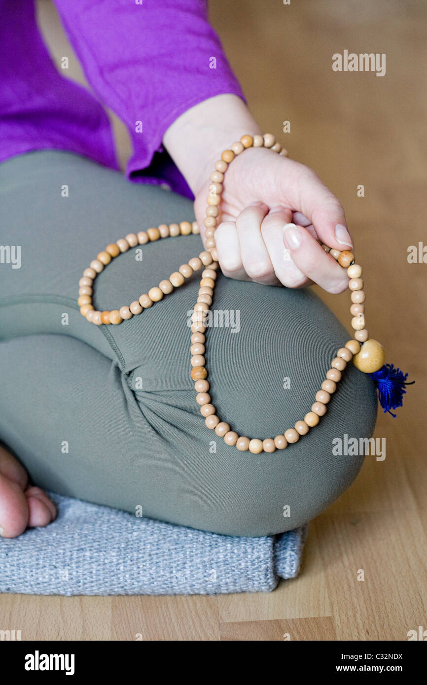 Woman kneeling holding beads Stock Photo