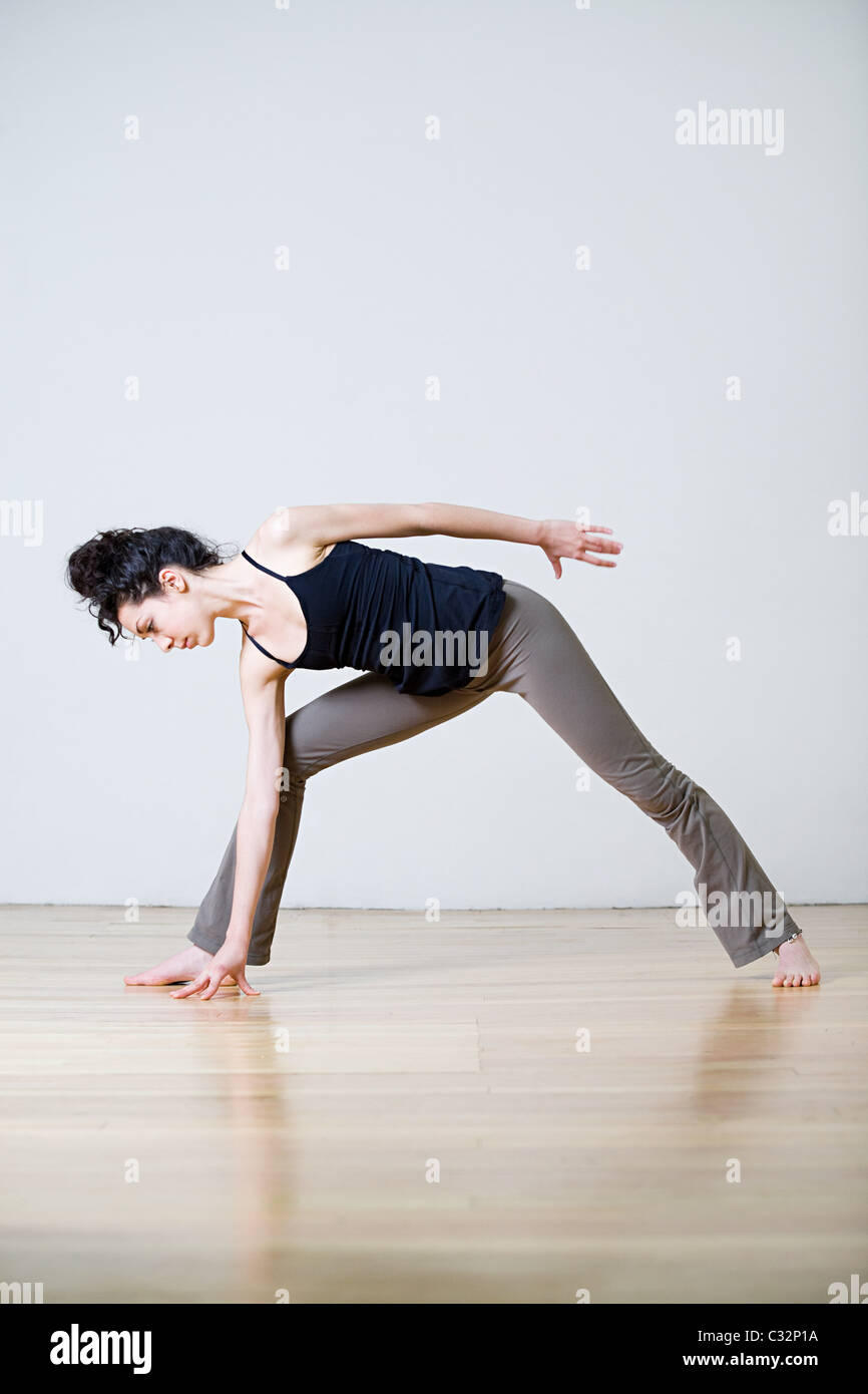 Woman in warrior position during yoga Stock Photo