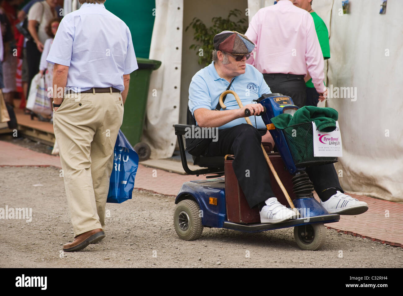 Senior man on mobility scooter amongst crowds at National Eisteddfod