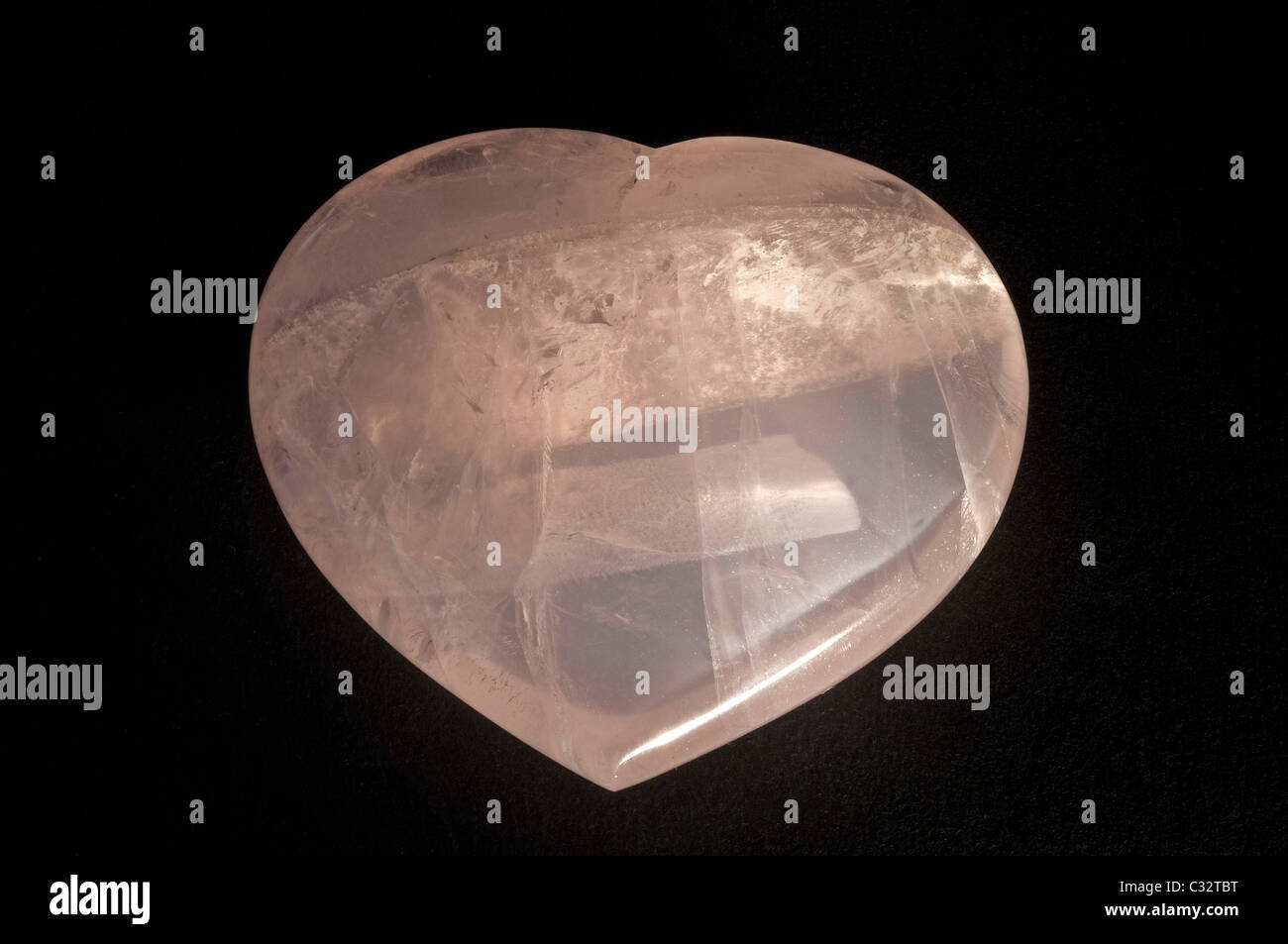 Heart made of Rose Quartz, studio picture against a blue background. Stock Photo