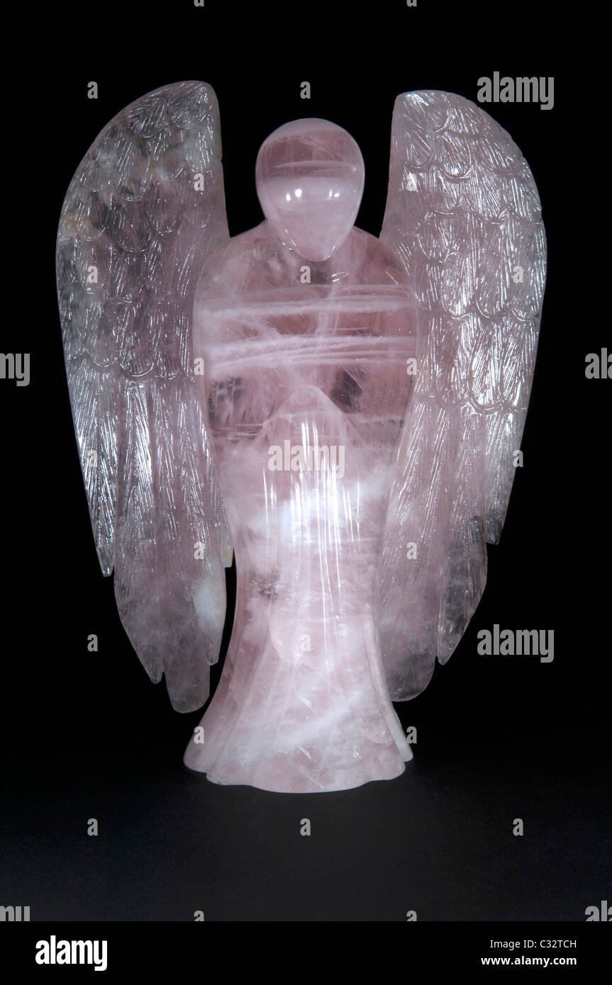 Angel made of Rose Quartz, studio picture against a black background. Stock Photo