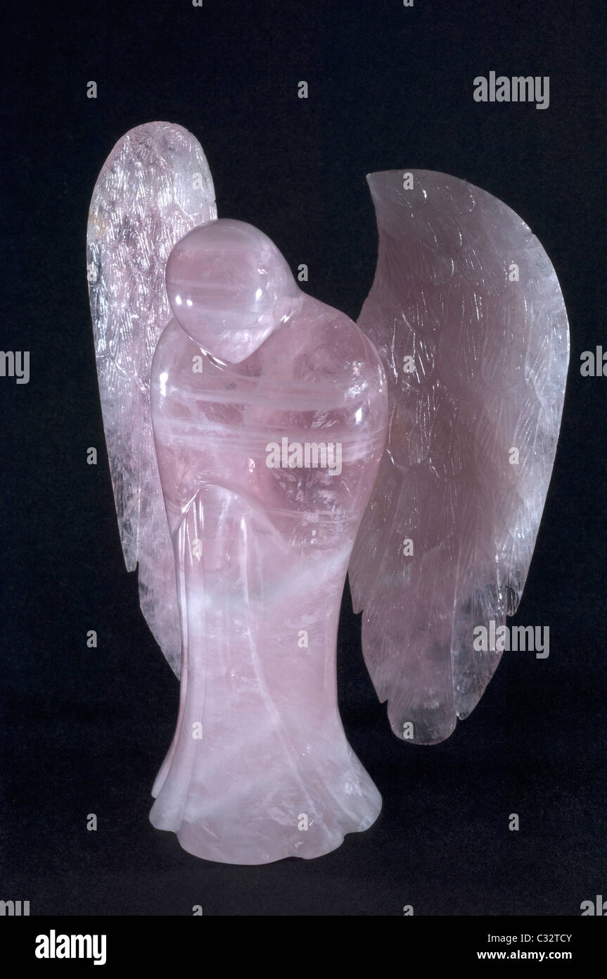 Angel made of Rose Quartz, studio picture against a black background. Stock Photo