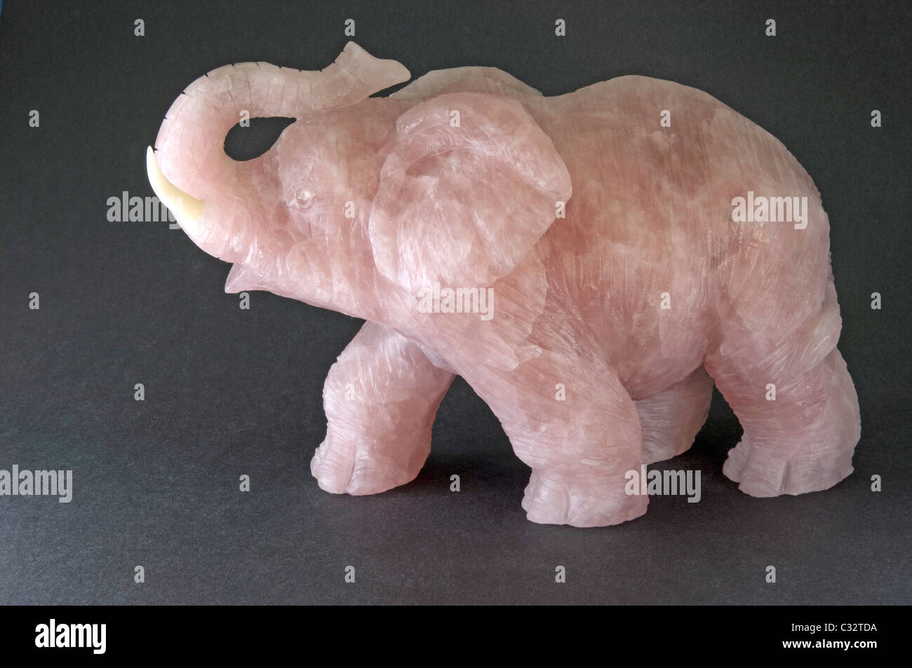 Elephant made of Rose Quartz, studio picture against a dark background. Stock Photo