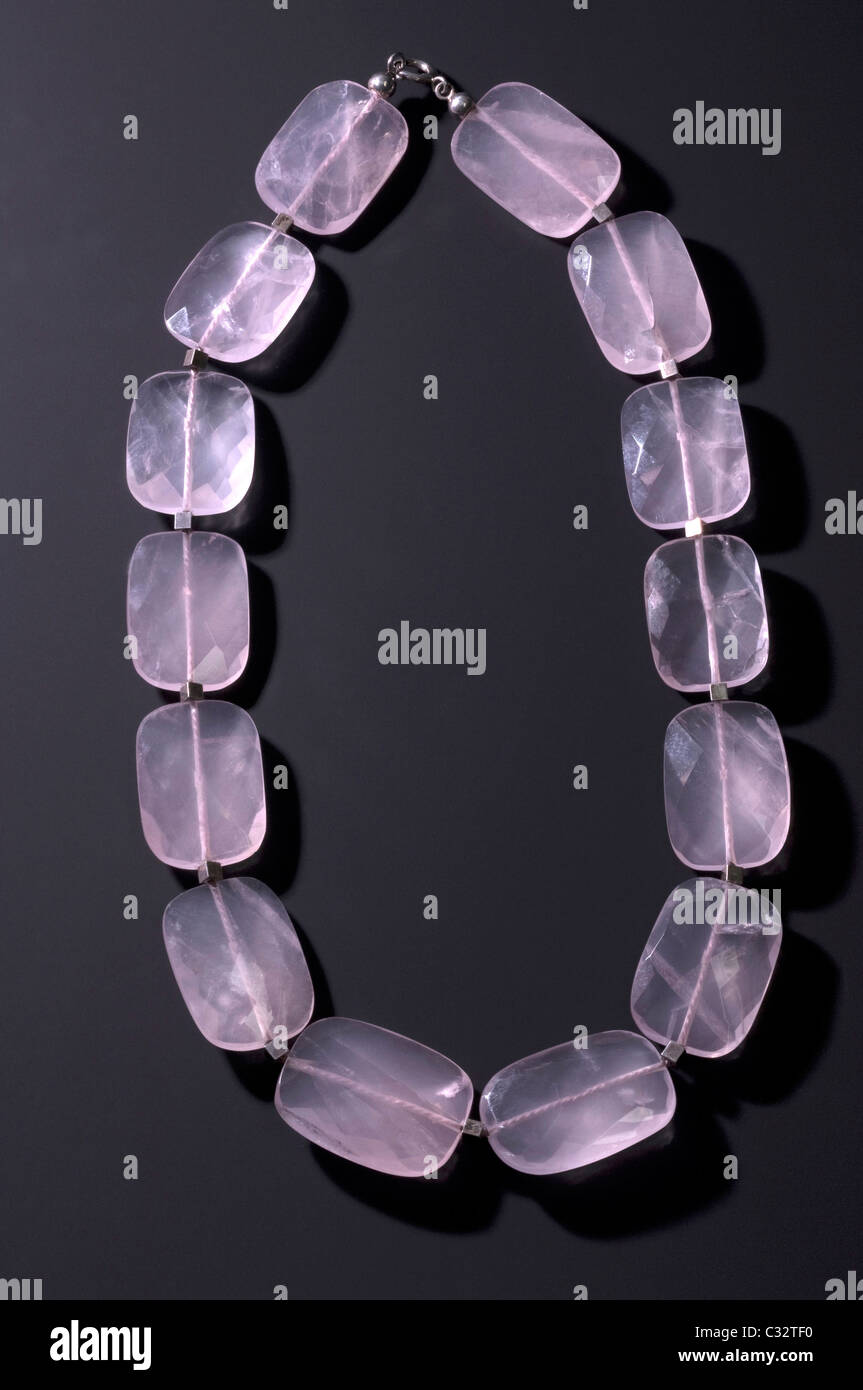 Necklace made of cut and polished plates of Rose Quartz, studio picture against a dark background. Stock Photo