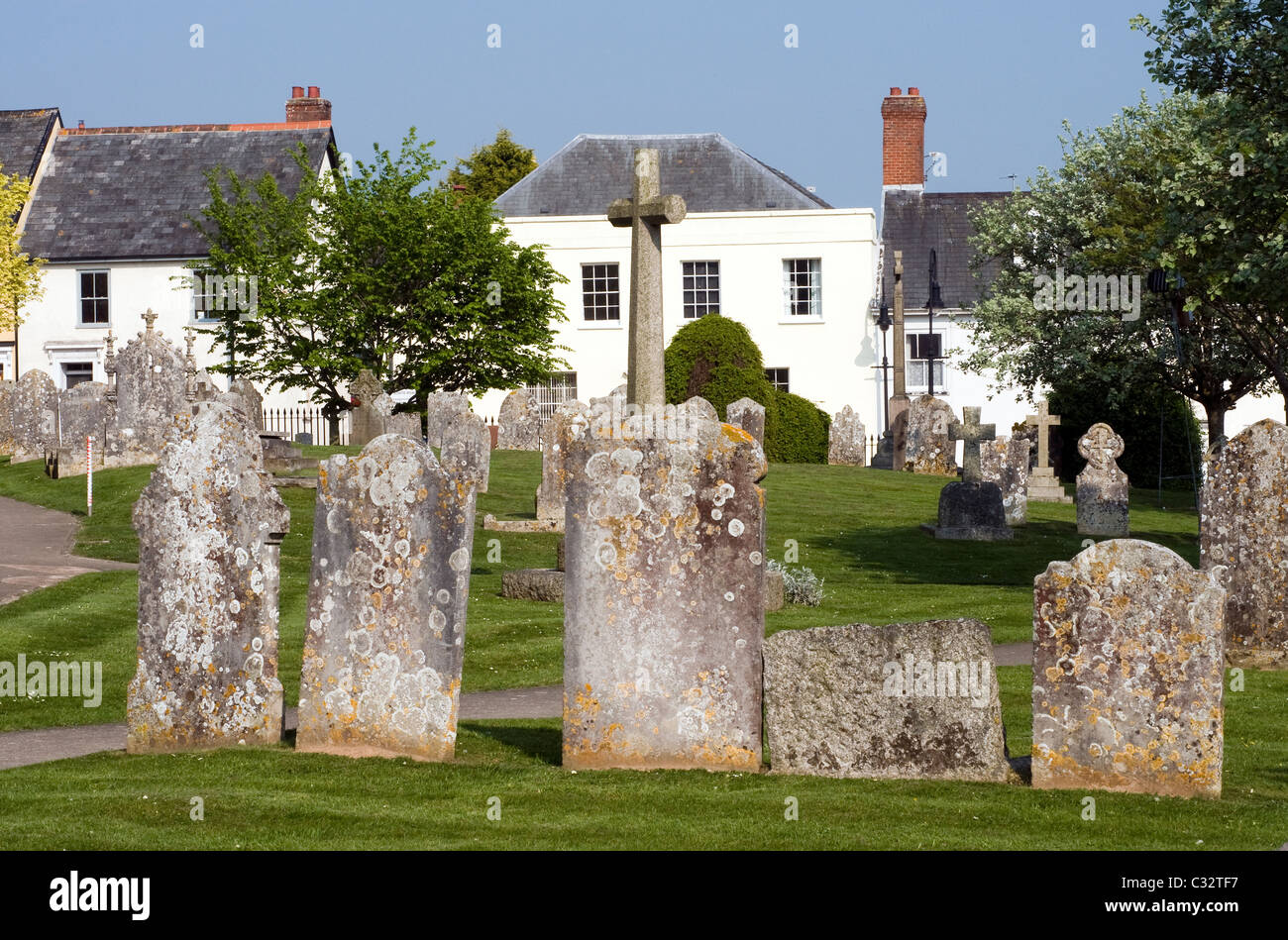 Gravestones and buildings in Ottery St Mary Devon, dead, grave, cross, crucifix Stock Photo