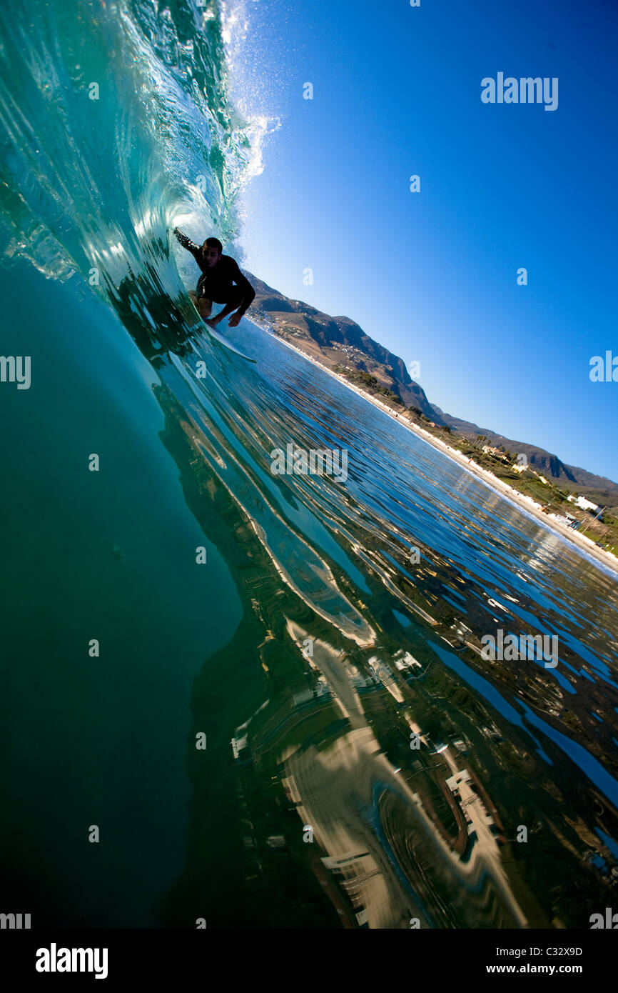 A male surfer stalls for a glassy barrel while surfing at Zuma Beach in Malibu, California. Stock Photo