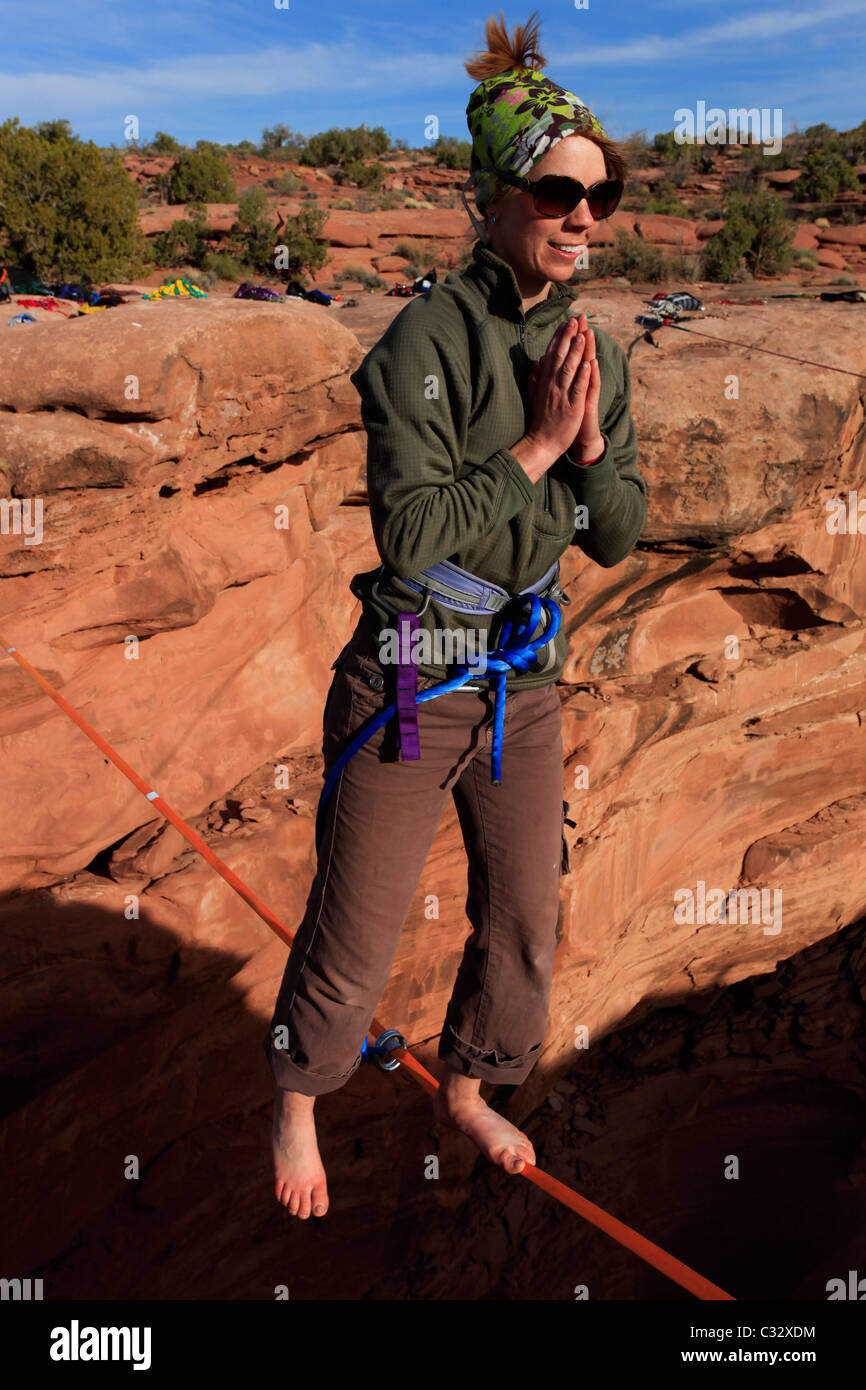 A female highliner poses on a highline at the Fruit Bowl in Moab, Utah