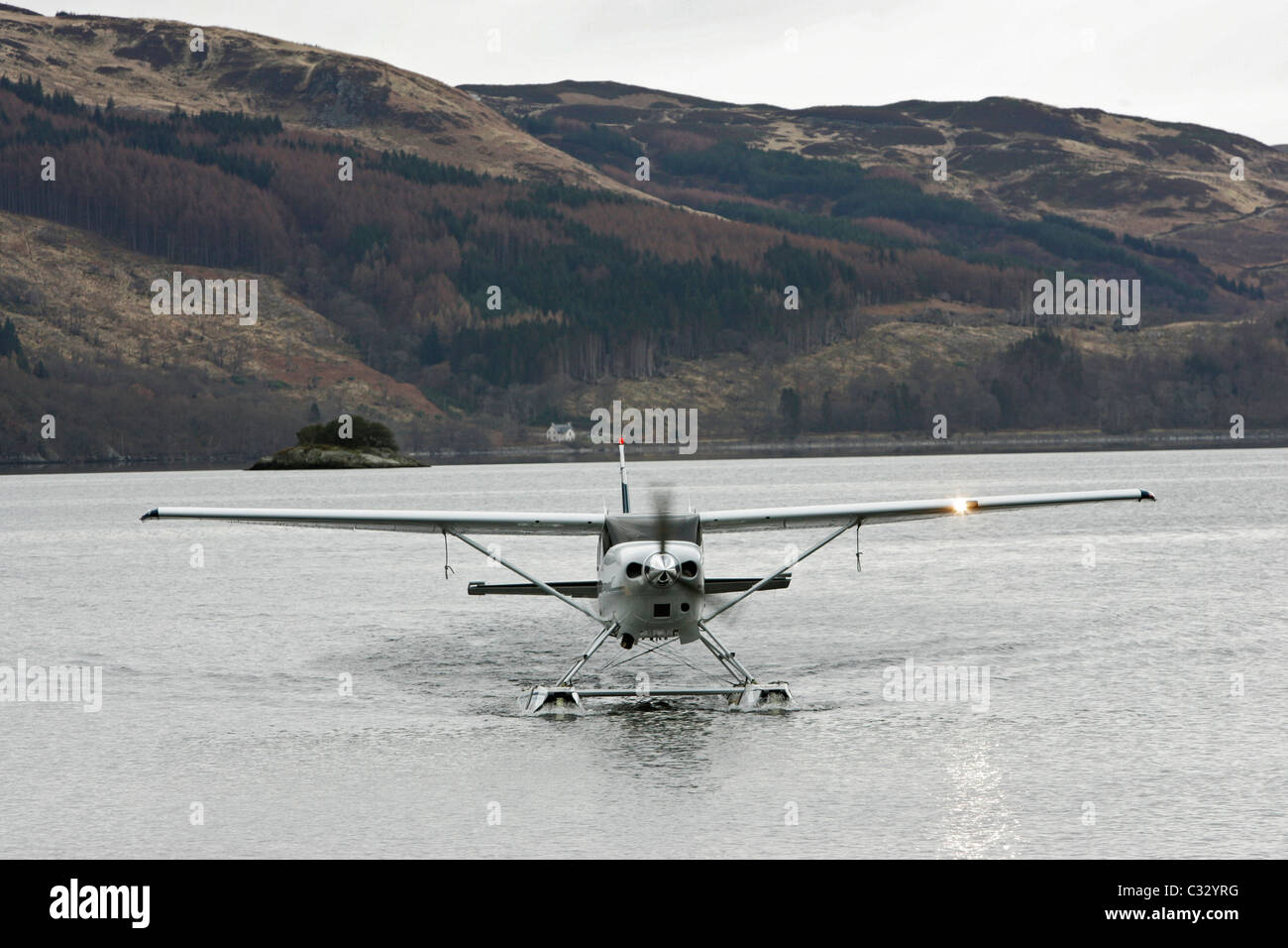 One of Loch Lomond Seaplanes aircraft taxiing towards shore on Loch Lomond Stock Photo