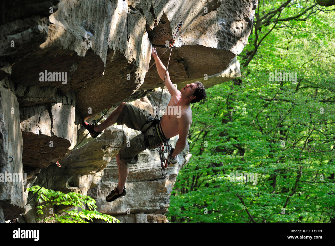 Rock climber climbing in sandstone cliff Wanterbaach at Berdorf, Little Switzerland / Mullerthal, Grand Duchy of Luxembourg Stock Photo