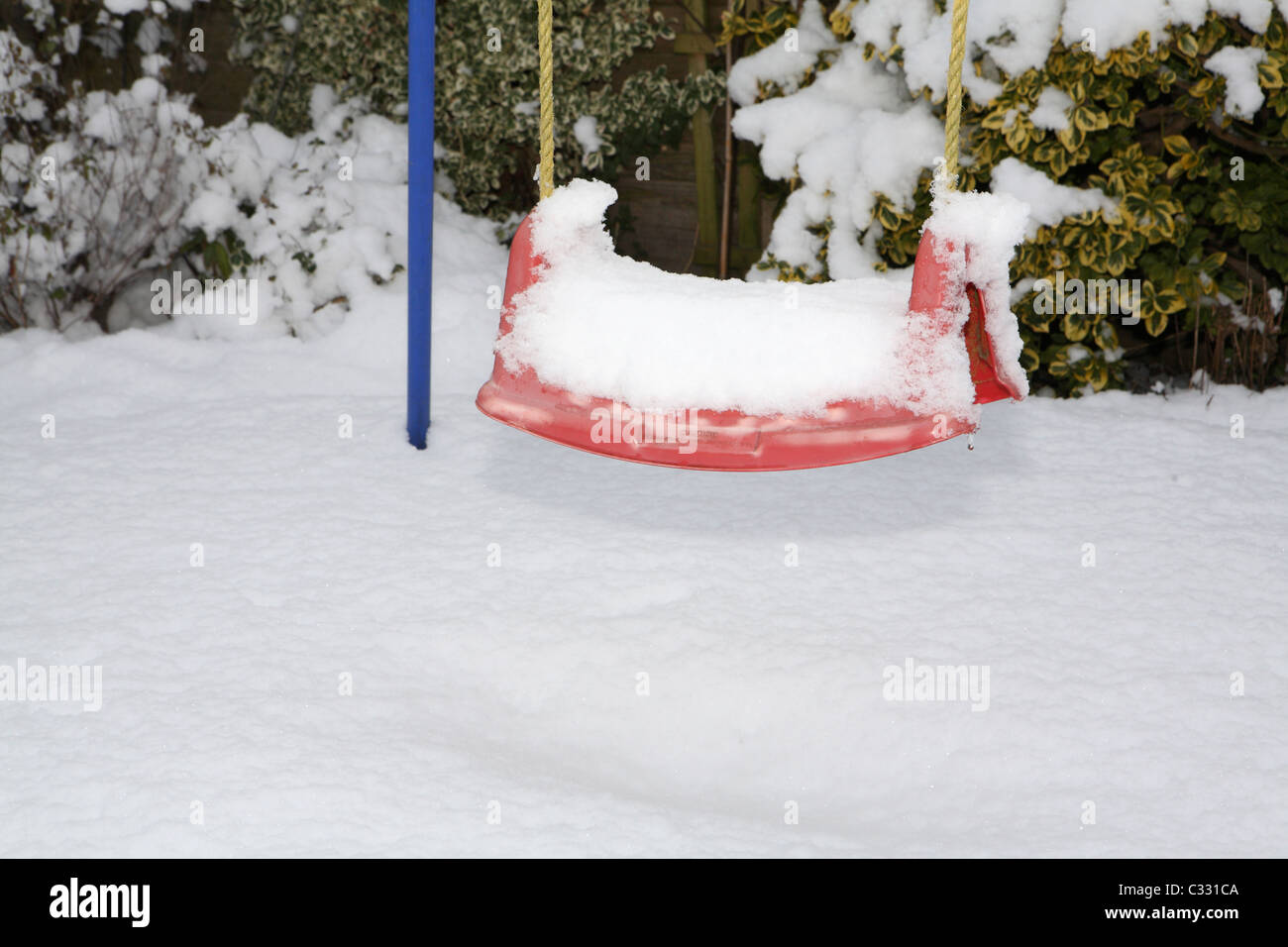Snow on child's swing Stock Photo