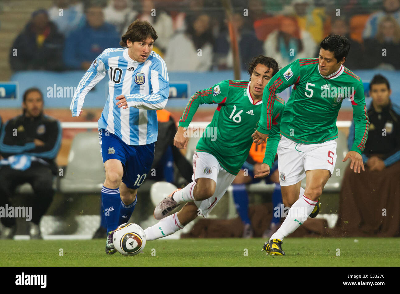 Lionel Messi of Argentina (10) attacks against Mexico's Efrain Juarez (16) and Ricardo Osorio (5) during a 2010 World Cup match Stock Photo
