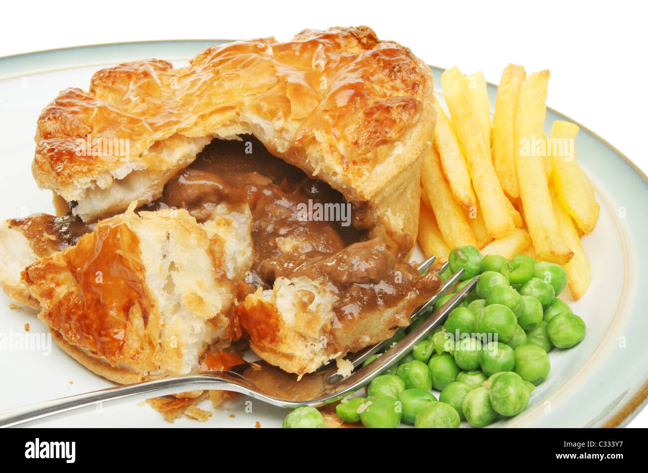 Beef pie chips and garden peas with a fork on a plate Stock Photo
