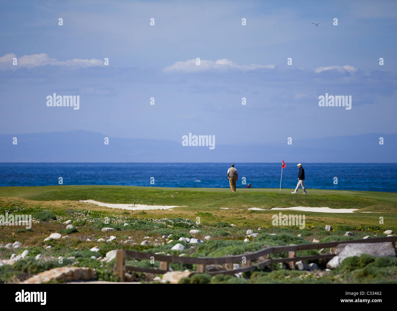 Golfers on putting green on the famous oceanfront Pebble Beach golf course Stock Photo