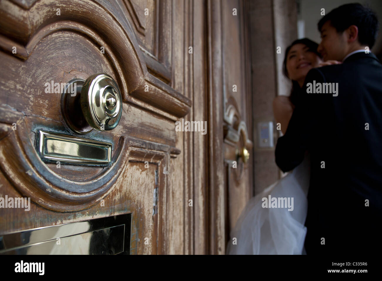 groom and bride outside a house with classic door Stock Photo - Alamy