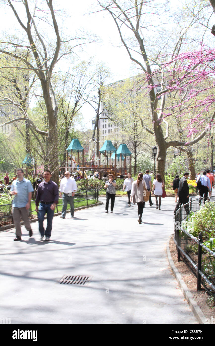 People walking during lunch hour at Madison Square Park in New York City Stock Photo