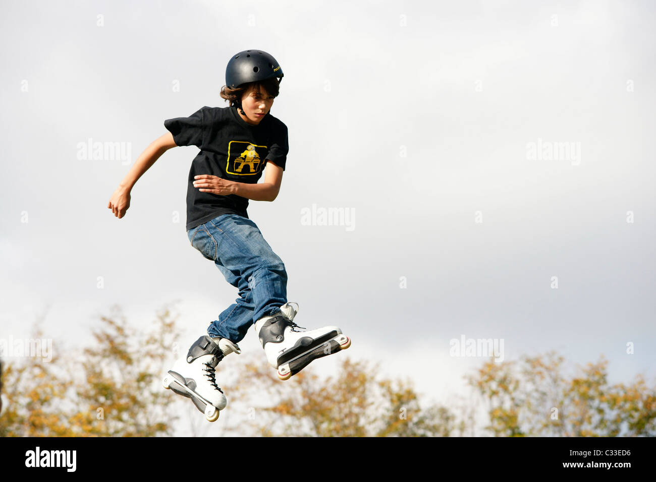 Young teenage boy man jumping with rollerblades inline skates on U ramp