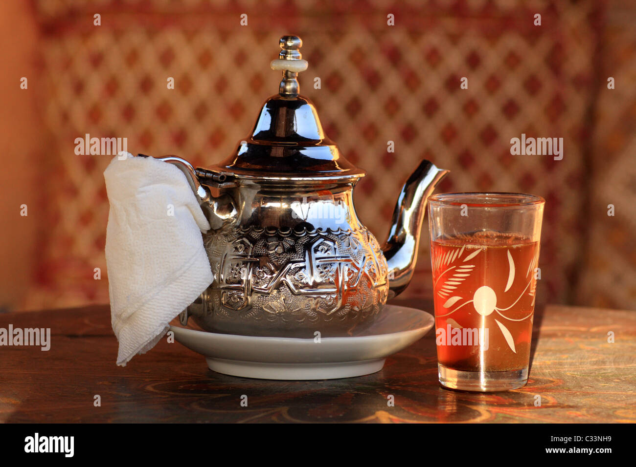 Glass of mint tea and ornate silver teapot served in Morocco, North