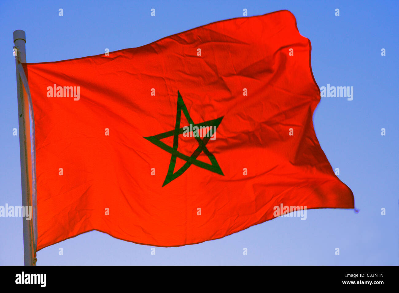 Morocco.s national flag flies on a pole against a cloudless springtime sky, Morocco, North Africa Stock Photo