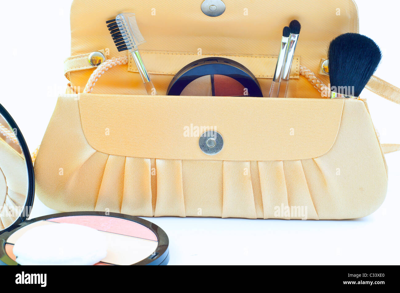 makeup brushes and blush in handbag on white background Stock Photo