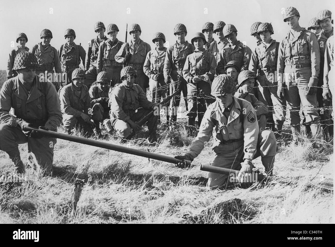 US GI soldiers prepare Bangalore torpedoes while training for D Day. Explosive device used for clearing barbed wire defenses. Stock Photo