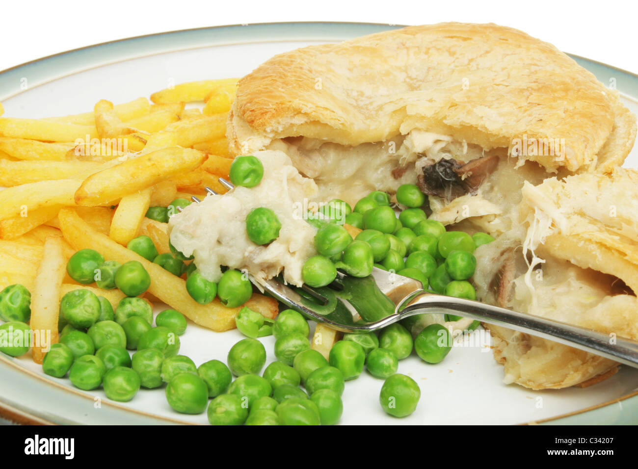 Chicken and mushroom pie with chips and peas on a plate Stock Photo