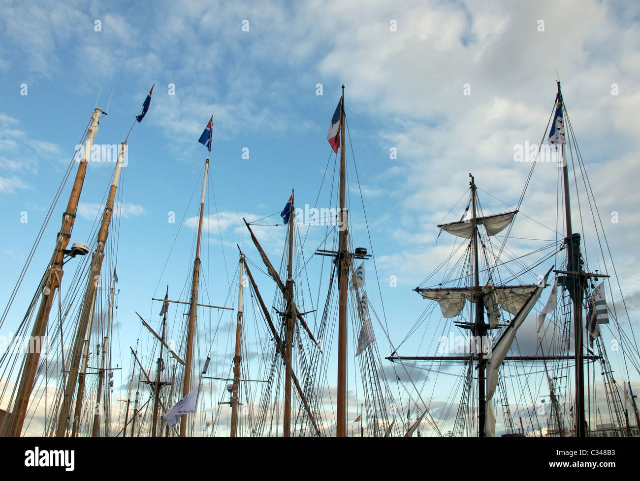 Ships masts with French Tricolore Flag and evening sky, Brest 2008 Maritime Festival, Brittany, France Stock Photo