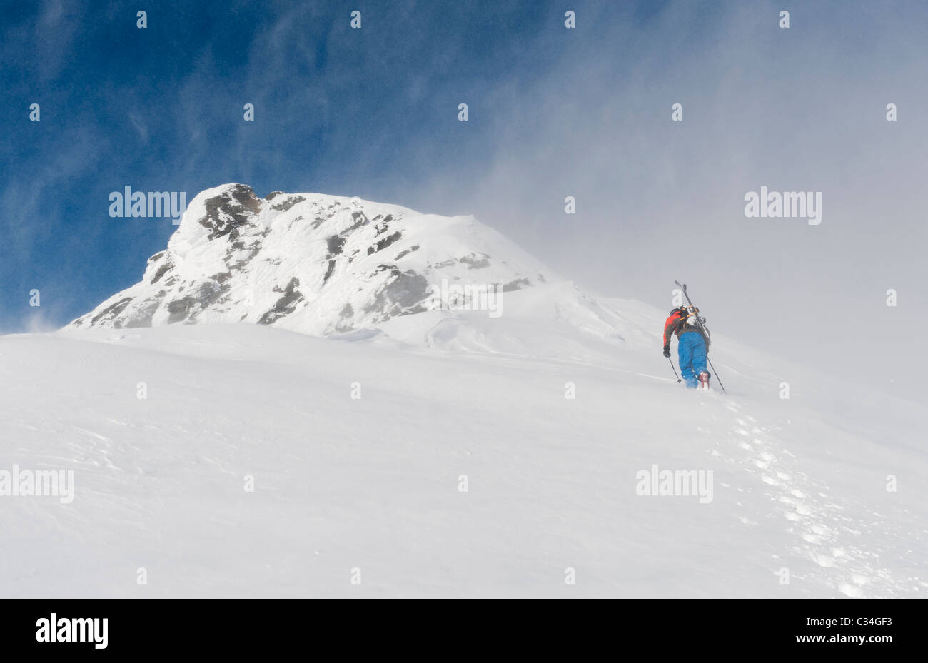 A free skier climbing up a snowy mountain side at Lofoten Islands, Norway Stock Photo