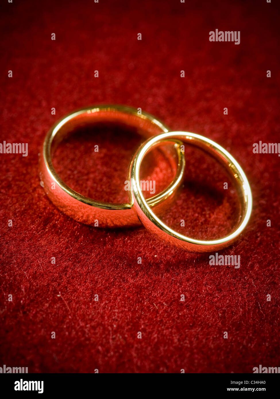 Overlapping plain gold wedding rings on red fabric Stock Photo Alamy