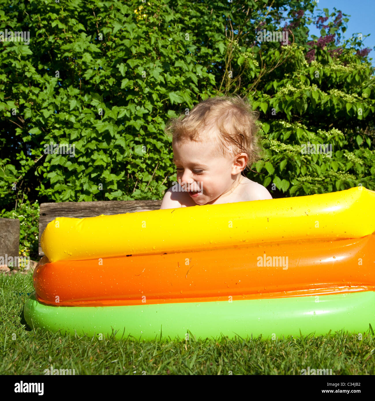 Boy (2 years old) playing in a paddling pool, Hampshire, England Stock