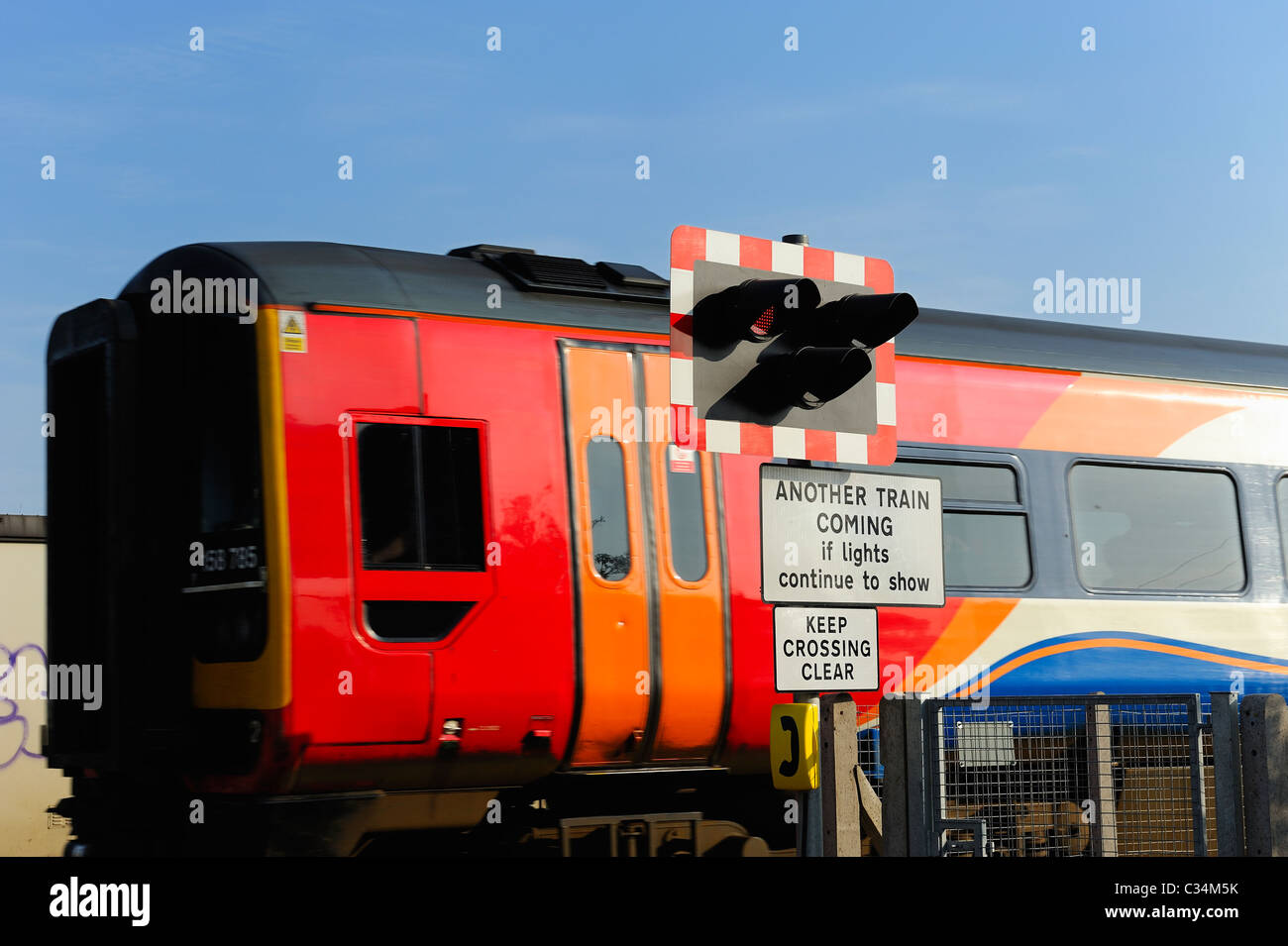 train passing railway crossing warning lights Beeston england uk Stock Photo