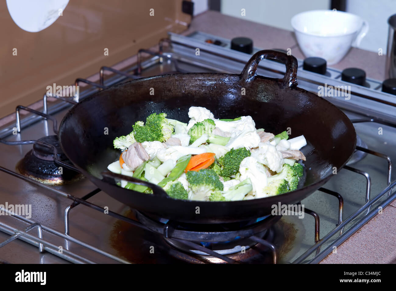 Stir Fry Broccoli Cauliflower Vegetable and Pork in Asian Wok Stock Photo