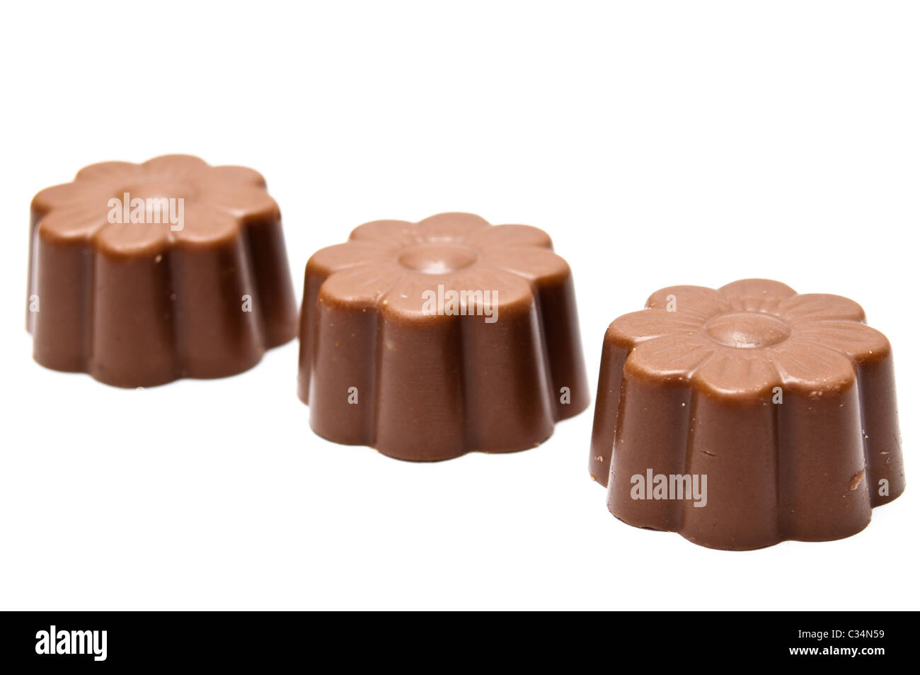 Three daisy shaped chocolate assortments in diagonal arrangement