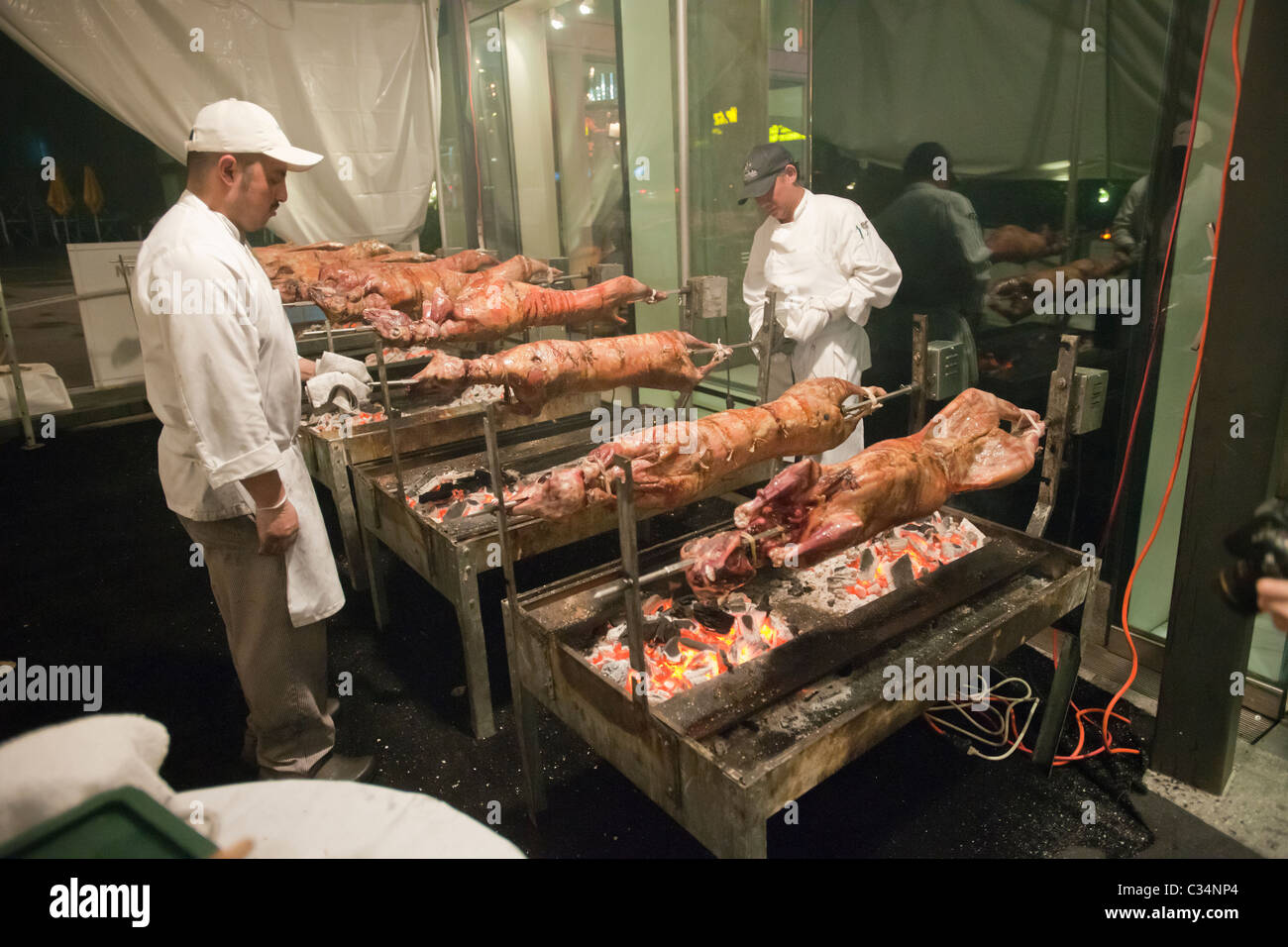 As the coals cool chefs lower the18 lambs roasting in front of a Greek